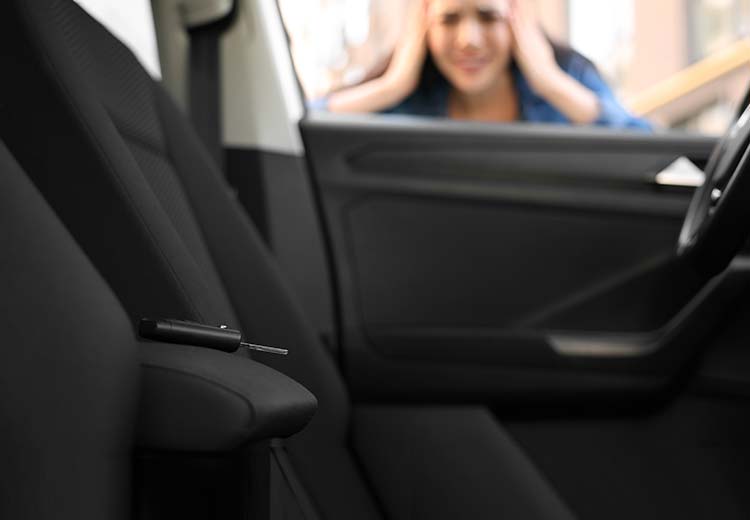 woman looking through car window to see if keys are locked in