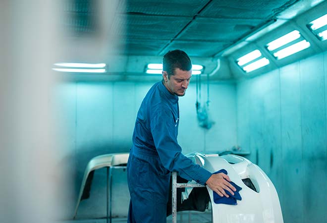 Man wiping bumper clean from a custom paint job.